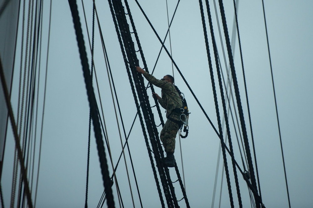 Sailors climb the shrouds aboard USS Constitution