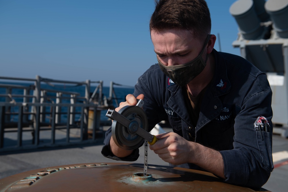 Sailor inspects the aft capstan’s lubrication oil level