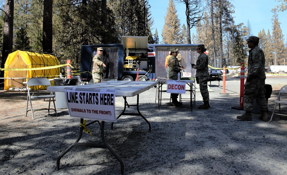 Dog tags and wags: Soldiers decontaminate search and rescue volunteers near North Complex Fire