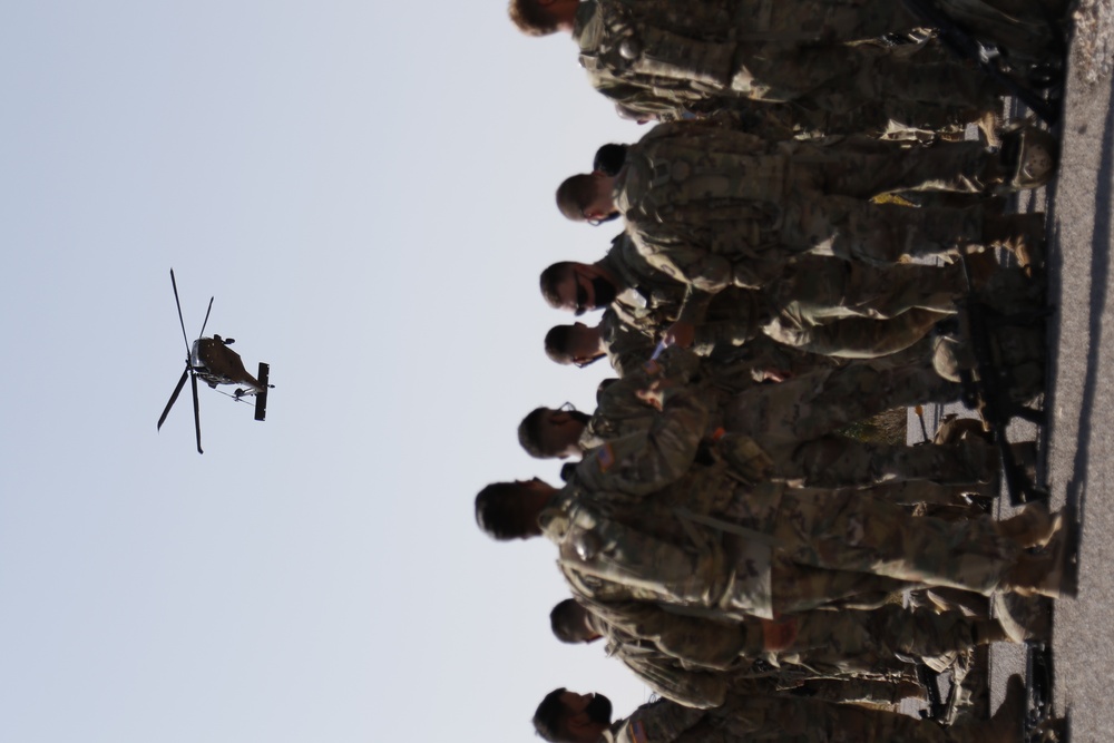 1-113th Soldiers move by Blackhawk