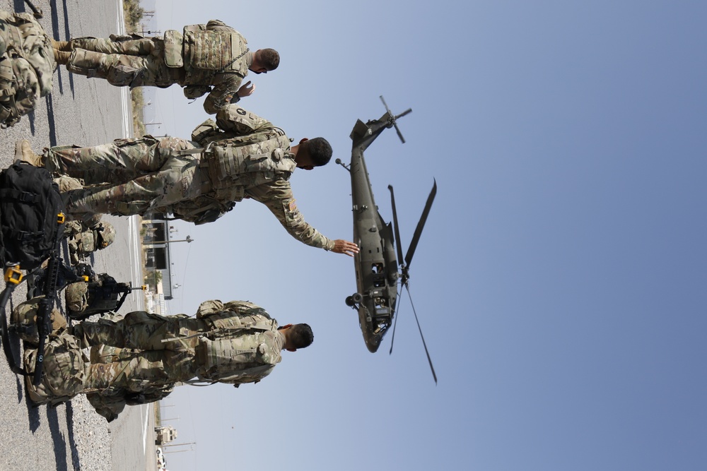 1-113th Soldiers move by Blackhawk