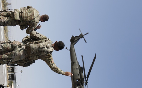 1-113th Soldiers move by Blackhawk