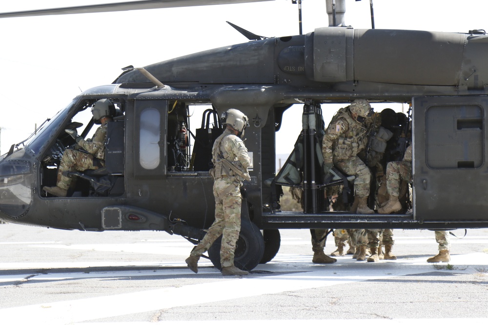 1-113th Soldiers move by Blackhawk