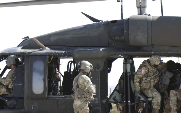 1-113th Soldiers move by Blackhawk