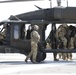 1-113th Soldiers move by Blackhawk