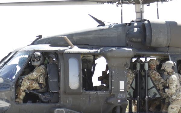 1-113th Soldiers move by Blackhawk