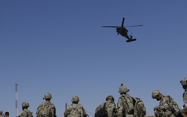 1-113th Soldiers move by Blackhawk