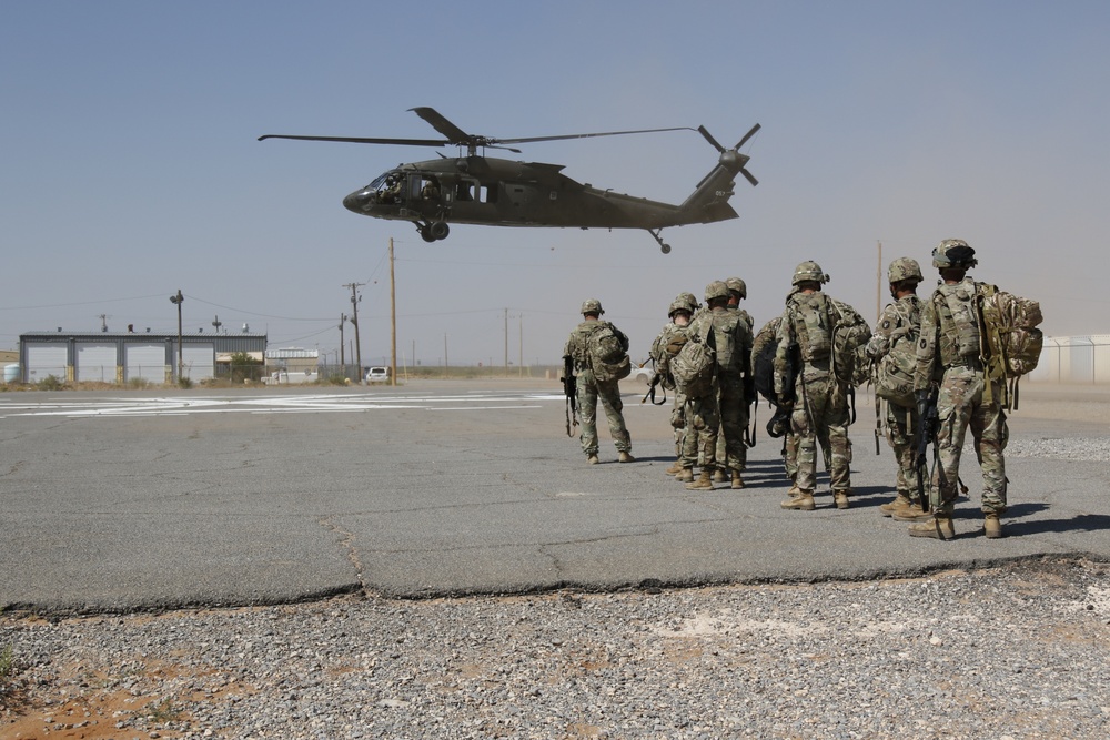 1-113th Soldiers move by Blackhawk