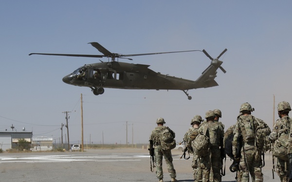 1-113th Soldiers move by Blackhawk