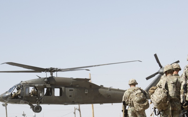 1-113th Soldiers move by Blackhawk