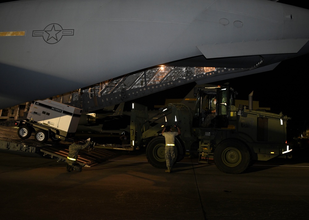 Ramp service technicians on-load a mobile field hospital onto a C-17