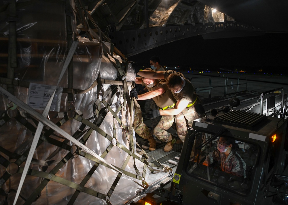 Ramp service technicians on-load a mobile field hospital onto a C-17