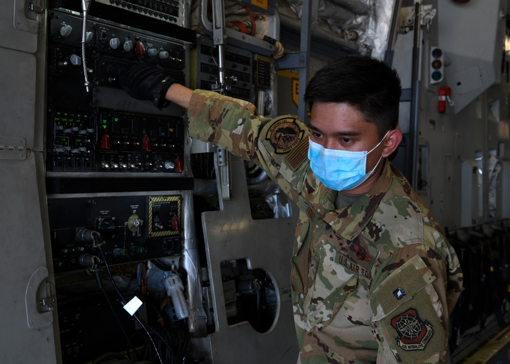 Airman First Class Virgilio Frial off-loads a mobile field hospital from a C-17