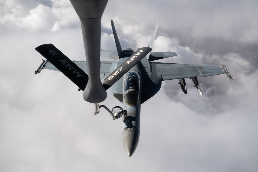 A U.S. Air Force KC-135 Stratotanker refuels Navy F/A-18 Super Hornets