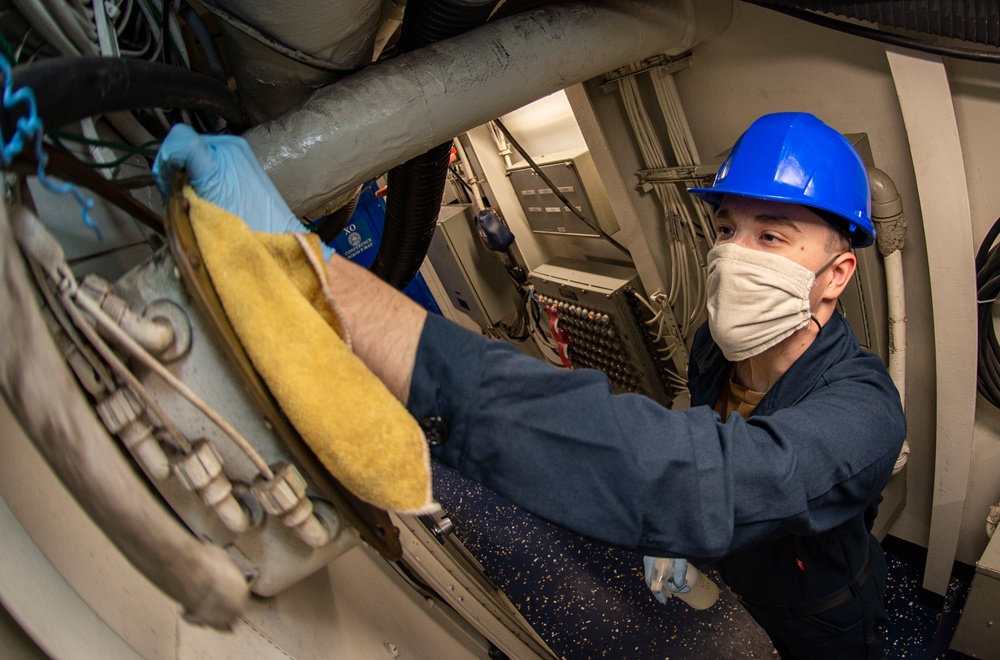GHWB Sailor Sanitizes Bulkhead