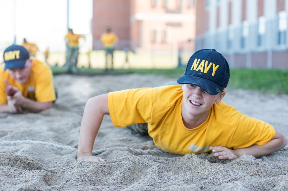 201014-N-TE695-0052 NEWPORT, R.I. (Oct. 14, 2020)  Navy Officer Candidate School (OCS) student low crawls at the obstacle course during battle stations