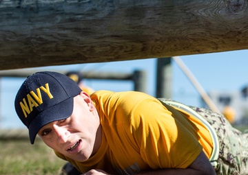 201014-N-TE695-0058 NEWPORT, R.I. (Oct. 14, 2020)  Navy Officer Candidate School (OCS) student low crawls at the obstacle course during battle stations