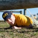 201014-N-TE695-0058 NEWPORT, R.I. (Oct. 14, 2020)  Navy Officer Candidate School (OCS) student low crawls at the obstacle course during battle stations