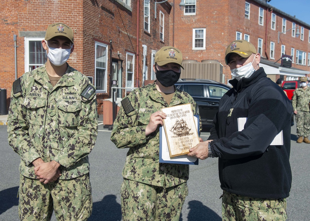 Logistics Specialist Seaman Patience Jones, middle, assigned to USS Constitution, is awarded Blue Jacket of the Quarter