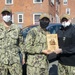 Aviation electrician's mate 3rd Class Zachary HansenMcPhail, middle, assigned to USS Constitution, is awarded Junior Sailor of the Quarter