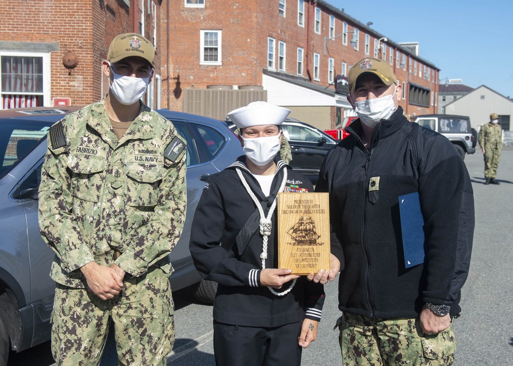 Boatswain’s Mate 2nd Class Jacklyn Ditzel, middle, assigned to USS Constitution, is awarded Sailor of the Quarter