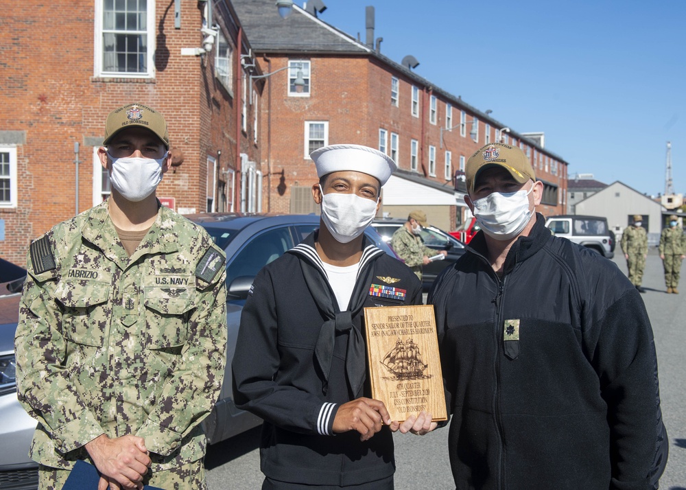 Naval Aircrewmen Helicopter 1st Class Charles Hardmon, middle, assigned to USS Constitution, is awarded Senior Sailor of the Quarter