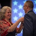 Air Force wife places retirement pin on her husband