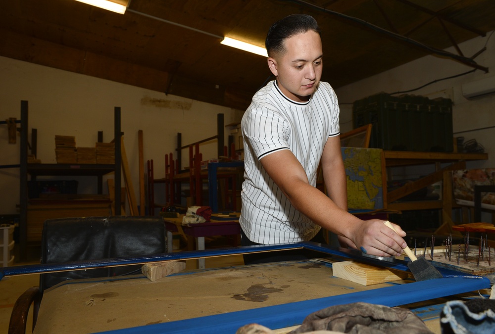 CAMP LEMONNIER SERVICE MEMBERS VOLUNTEER PAINTING FRAMES FOR GALLEY