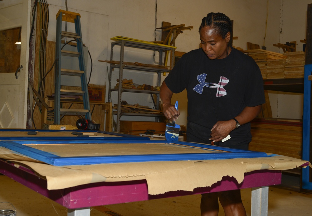 CAMP LEMONNIER SERVICE MEMBERS VOLUNTEER PAINTING FRAMES FOR GALLEY