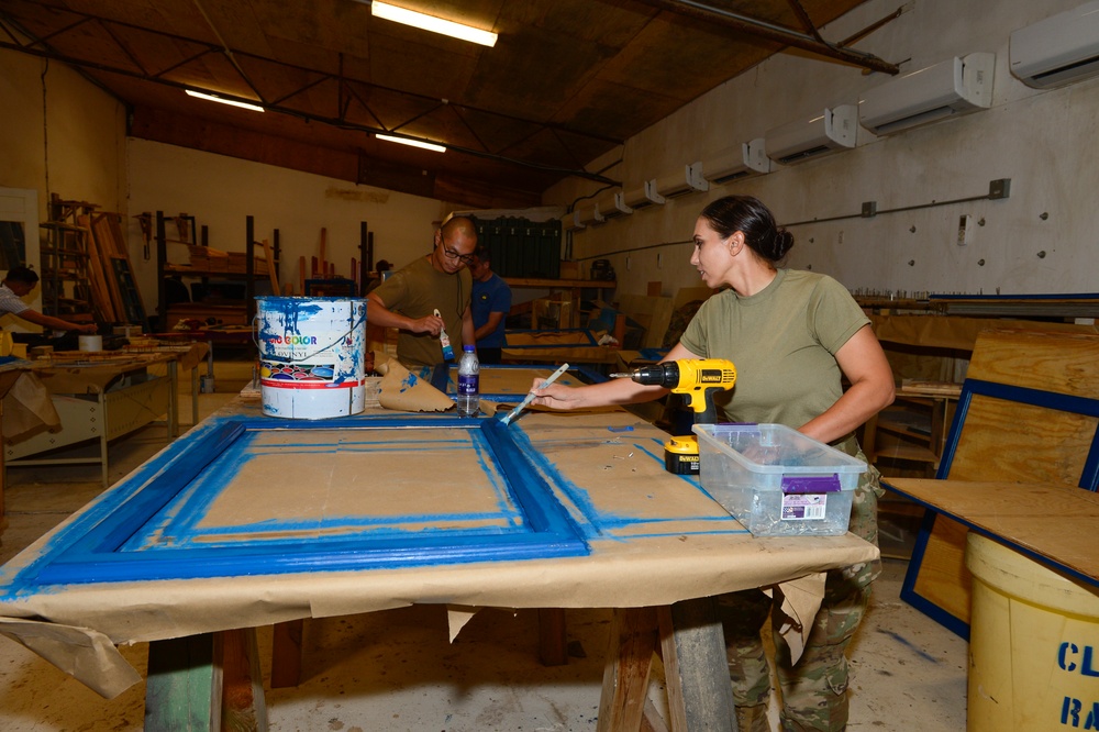 CAMP LEMONNIER SERVICE MEMBERS VOLUNTEER PAINTING FRAMES FOR GALLEY