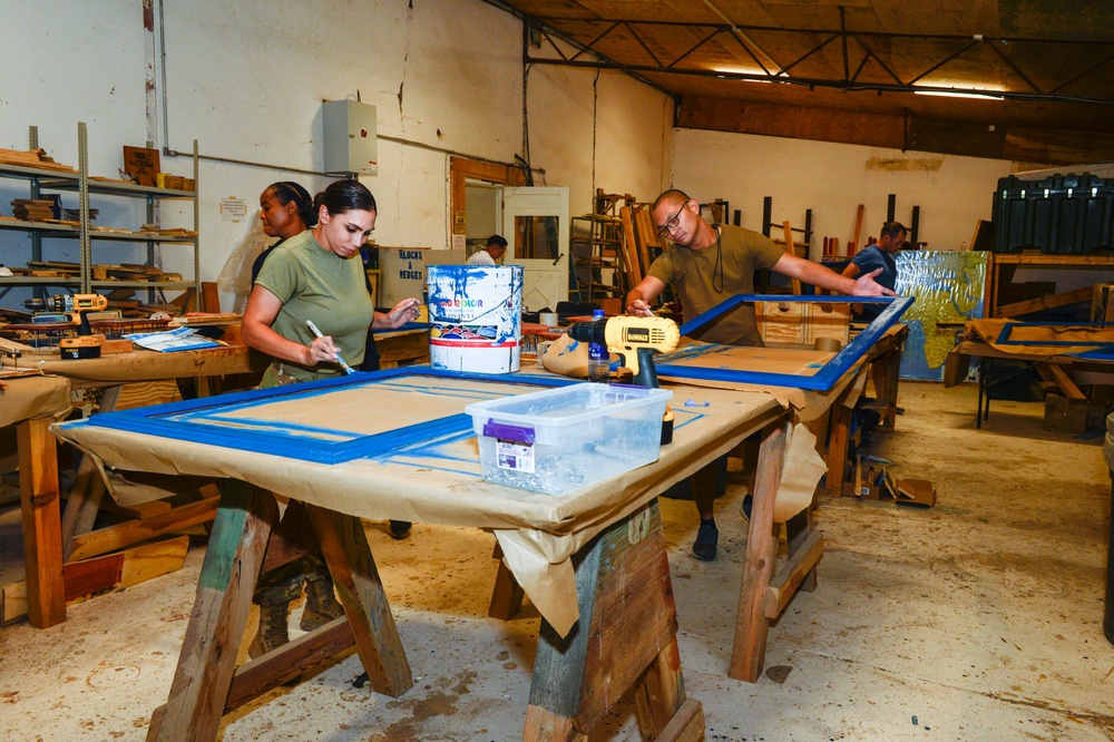 CAMP LEMONNIER SERVICE MEMBERS VOLUNTEER PAINTING FRAMES FOR GALLEY