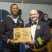 Retail Services Specialist 1st Class Kenneth Johnson (left) assigned to USS Constitution, is awarded the Top Guardsman Award by the 76th commanding officer of USS Constitution, Cmdr. John A. Benda (right)