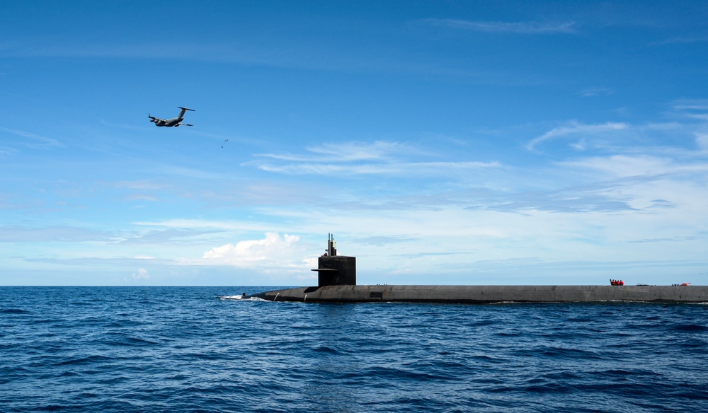 A C-17 Globemaster III Air Drops A Payload to USS Henry M. Jackson