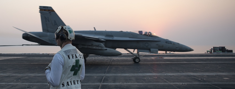 Sailor Observes F/A-18C Hornet Make Arrested Landing