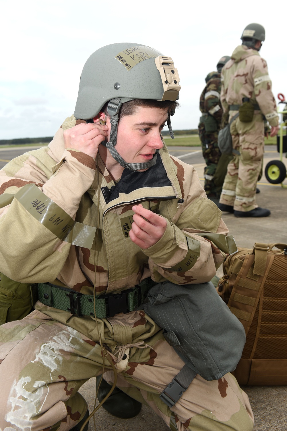 Maintainers, aircrew test in-ear headset during CBRN exercise