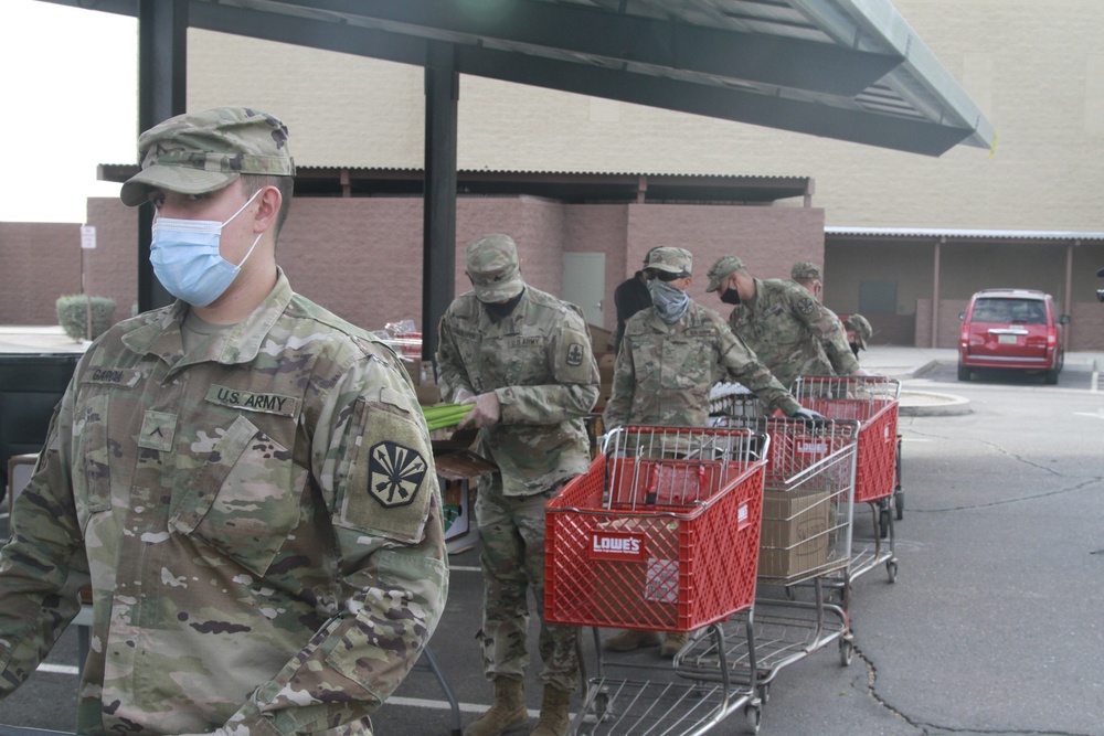 Arizona National Guard members load food into local residents vehicles from local food banks.