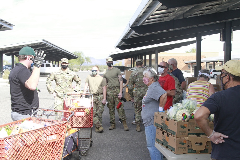 Arizona National Guard members load food into local residents vehicles from local food banks.