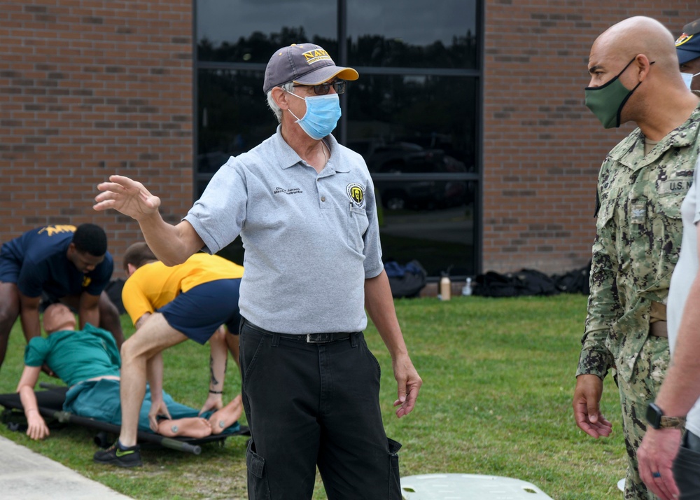 CAPT Ewing and CMC McDermott watch as Sailors receive DECON Training