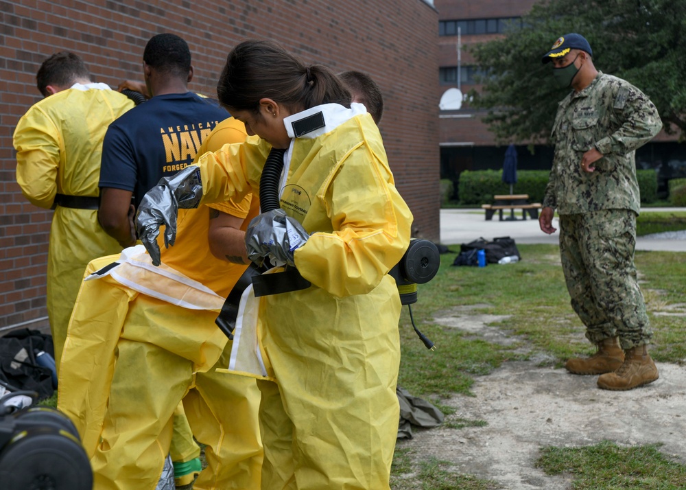 CAPT Ewing and CMC McDermott watch as Sailors receive DECON Training