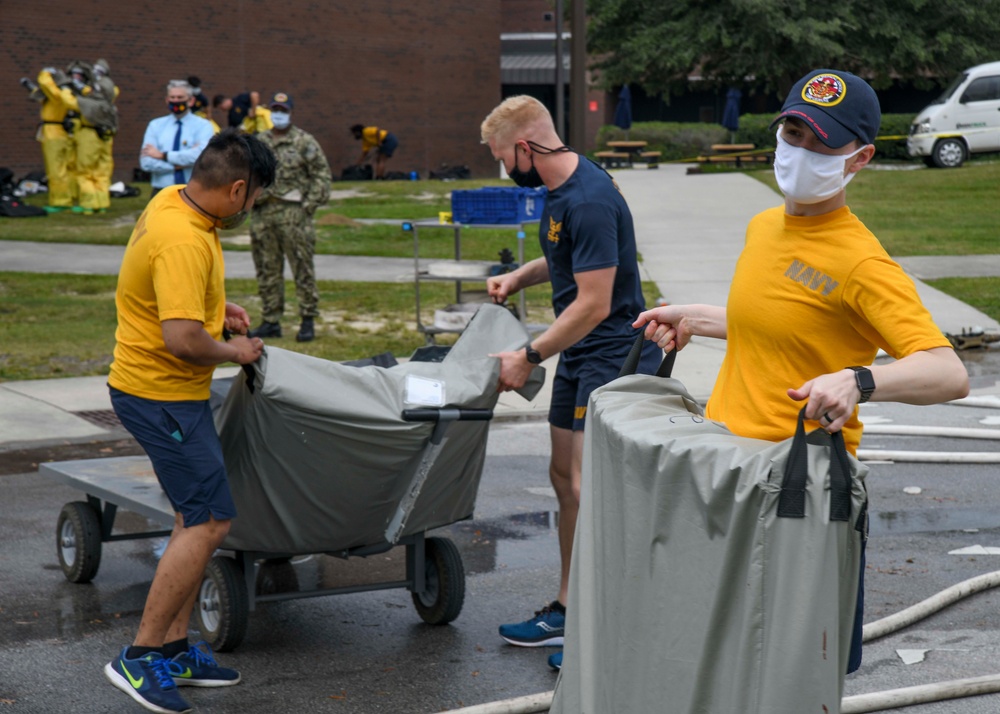 CAPT Ewing and CMC McDermott watch as Sailors receive DECON Training