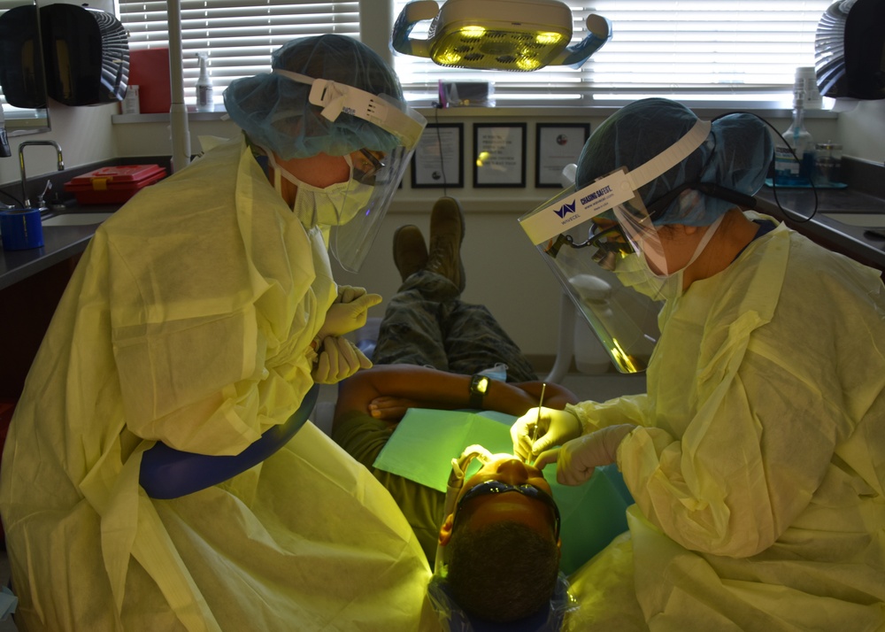 Hospitalman Hailey Lavoie (left) and Lt. Cmdr. Calen Lee perform a dental procedure on a patient