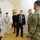 Guard medical team supports Czech partners A group of people wearing face masks are gathered in what appears to be a medical facility or hospital room. The group includes two individuals in US Army MultiCam (OCP) camouflage uniforms, several medical staff in white scrubs and lab coats, and civilians in business attire. The meeting appears to be a formal coordination or briefing between military personnel and healthcare staff.