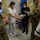 Guard medical team supports Czech partners Military personnel in OCP (Operational Camouflage Pattern) uniforms interact with medical staff in what appears to be a hospital or clinical setting. A nurse in white scrubs is handing or exchanging a box or package with a soldier, while others observe. All individuals are wearing face masks, suggesting this occurred during the COVID-19 pandemic period.