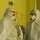 Guard medical team supports Czech partners Several individuals are wearing full personal protective equipment (PPE) including white hazmat-style suits, respirator masks with red valves, safety goggles, and head coverings in what appears to be a medical or clinical facility. The setting features a yellow-painted wall, a wall clock, and a visible IV stand in the background. The scene is consistent with infection control protocols, likely in a hospital or quarantine environment.