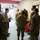 Guard medical team visits Czech Military University Hospital Prague A group of U.S. Army personnel in camouflage uniforms are gathered in what appears to be a Czech medical facility, identifiable by the sign reading 'EXPEKTAČNÍ LŮŽKO' (Expectation/Observation Bed in Czech). All individuals are wearing face masks, suggesting this occurred during the COVID-19 pandemic period. A civilian in a gray shirt appears to be briefing or guiding the military personnel through the facility.