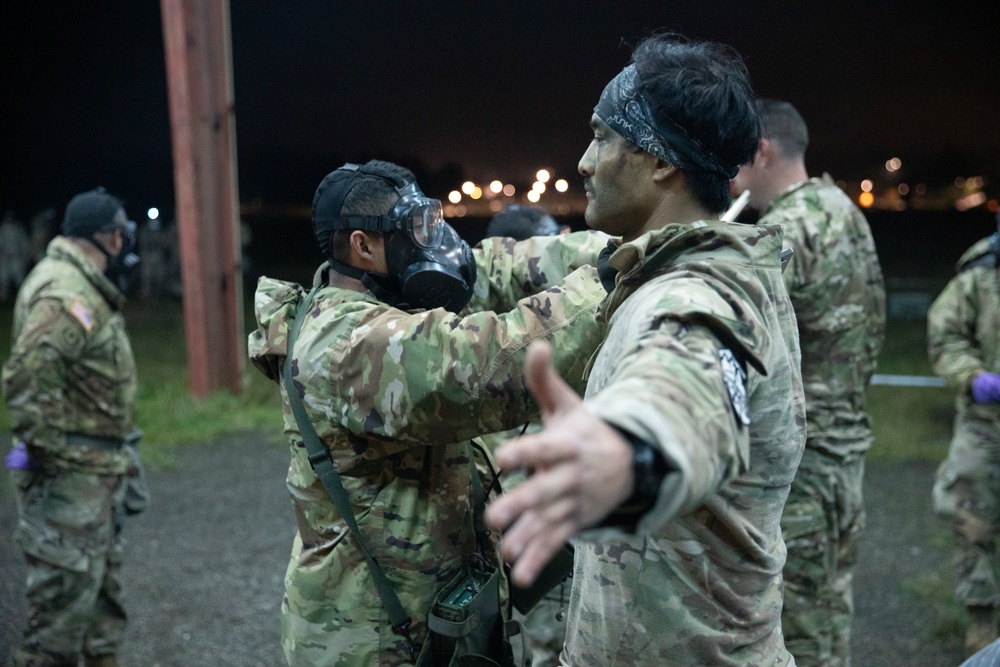 A Green Beret is notionally decontaminated by a soldier