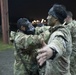 A Green Beret is notionally decontaminated by a soldier