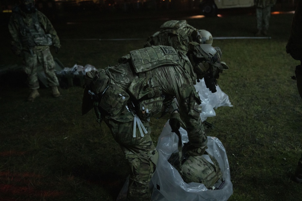 Green Berets with 1st Special Forces Group (Airborne) remove their gear after evacuation from an objective