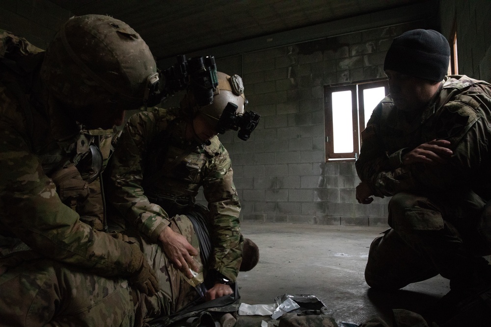 Soldier assists Green Beret giving first aid during training exercise