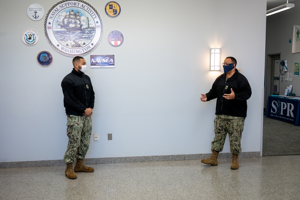 Master-at-Arms 1st Class Damon Harris reenlists in the United States Navy